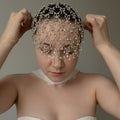 Woman wearing a decorative headpiece with beads against a neutral background, Obroi