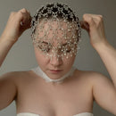 Woman wearing a decorative headpiece with beads against a neutral background, Obroi
