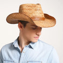 Man wearing a straw cowboy hat on a plain background, Obroi