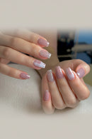 Close-up of hands with pink and glittery nail polish on a neutral background, Obroi