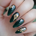 Green nails with gold leaf designs on a hand, Obroi