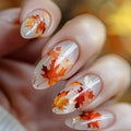 Nails with autumn leaf design on a blurred background, Obroi