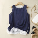 Navy blue sleeveless top with white lace trim on a beige surface, surrounded by shoes and a handbag, Obroi