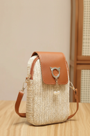 Woven handbag with brown leather accents on a wooden surface, Obroi