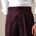 Maroon pleated pants worn with a white shirt on a neutral background, Obroi