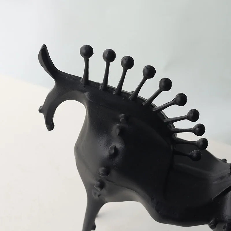Black sculpture of a creature with a spiked head on a white background, Obroi