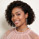 Woman with curly hair wearing a pink top against a plain background, Obroi