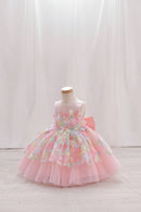 A pink toddler girl's party dress displayed on a mannequin. The dress features a sleeveless bodice with 3D floral appliques in pastel pink, green, and blue, layered over a voluminous tiered pink tulle skirt, Obroi