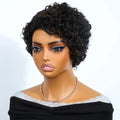 Short curly wig on a mannequin bust with a black off-the-shoulder top and a delicate rhinestone necklace, photographed against a plain light background, Obroi