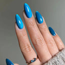 Hand with blue nail polish on a gray background, Obroi