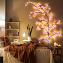 Decorative LED cherry blossom branch in a bedroom setting with warm lighting, Obroi