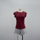 A short-sleeve crewneck t-shirt in burgundy with a small black polka dot pattern, displayed on a mannequin torso paired with light-wash denim shorts against a neutral gray background, Obroi
