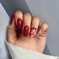Hand with red and cherry nail designs on a neutral background, Obroi