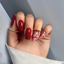 Hand with red and cherry nail designs on a neutral background, Obroi