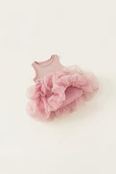 A baby girl's sleeveless pink bodysuit with a layered, ruffled tulle tutu skirt, laid flat on a warm off-white background, Obroi