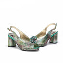 Green high-heeled shoes with decorative brooch on a white background, brand 'Obroi' visible.