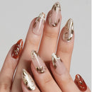 Nails with gold and red designs on a neutral background, Obroi