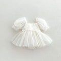 White baby dress with puffed sleeves on a light gray background, Obroi