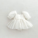 White baby dress with puffed sleeves on a light gray background, Obroi