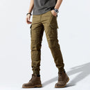 Person wearing olive green cargo pants and brown boots on a white background, Obroi