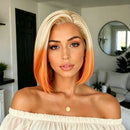 A woman with a short blonde-to-orange ombre bob hairstyle, wearing an off-the-shoulder cream top and a small gold pendant necklace, posing in a modern living room setting, Obroi