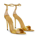 Gold high-heeled sandals on a white background, Obroi