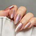 A close-up of a hand with almond-shaped nails painted in a shimmery iridescent pink nail polish that shifts with light, resting against a white fabric surface, Obroi