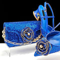Blue sequin clutch and high-heeled shoes with floral embellishments on a black background, Obroi