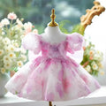 Pink dress on a mannequin with a blurred floral background, Obroi