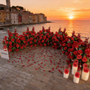 Decorative setup with red roses and candles by the sea at sunset , Obroi