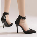 Black high-heeled shoes with lace detailing worn by a person on a light background, Obroi