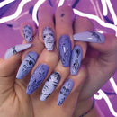 Hand with purple and white nail art against a neon pink background, Obroi