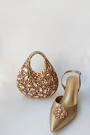 Gold handbag and shoe with embellishments on a light background, Obroi