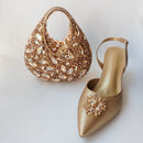 Gold handbag and shoe with embellishments on a light background, Obroi