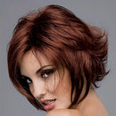 Woman with styled brown hair against a gray background, Obroi