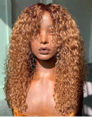 A close-up of a mannequin bust wearing a full, long, tightly curled wig with warm honey-blonde and golden-brown tones against a pale mint-gray background, Obroi