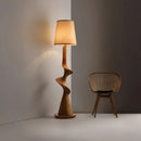 Wooden floor lamp with a wicker chair against a gray wall, Obroi