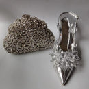 Silver clutch and shoe with floral design on a gray background, Obroi
