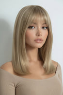 Woman with a styled blonde wig on a plain background, Obroi