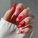 Hand with red and pink nail art on a neutral background, Obroi