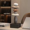 Stack of stones on a black base in a modern interior setting, Obroi