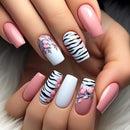Nails with floral and zebra pattern designs on a neutral background