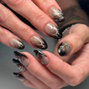 Close-up of hands with black and silver nail art on a neutral background, Obroi