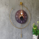 Modern wall clock with gold frame and dark face on a concrete wall, Obroi