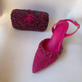Pink high-heeled shoe with embellishments and matching clutch on a white background, Obroi