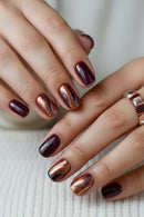 Close-up of hands with maroon and bronze nail polish, Obroi