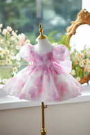 Pink and white floral dress on a mannequin with a blurred floral background, Obroi