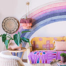 Colorful living room with a rainbow wall mural, yellow sofa, and decorative elements, Obroi
