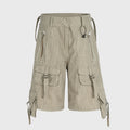 Beige cargo shorts with multiple pockets and straps on a light gray background, Obroi
