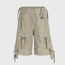 Beige cargo shorts with multiple pockets and straps on a light gray background, Obroi